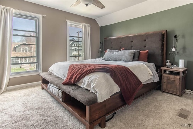 bedroom featuring light colored carpet, baseboards, and multiple windows