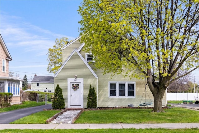 view of front of property featuring fence and a front lawn