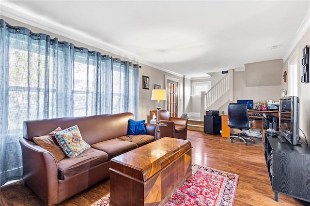 living room featuring ornamental molding, wood finished floors, and stairway