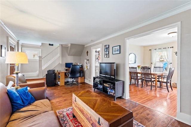 living room featuring crown molding, stairway, and wood finished floors