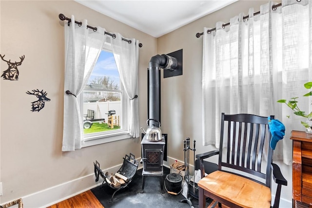 living area featuring baseboards and a wood stove