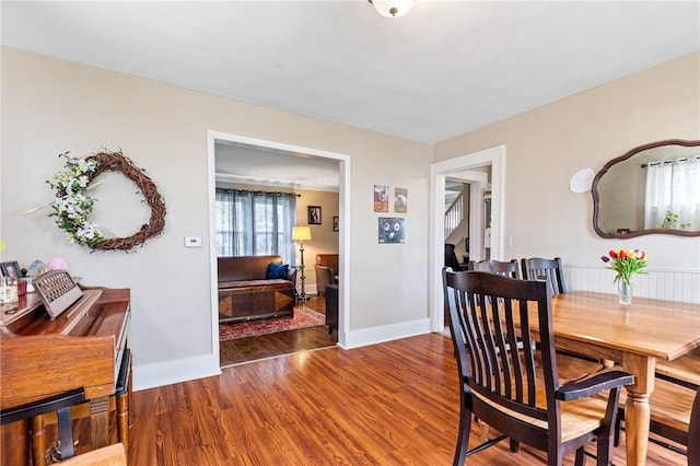 dining area with baseboards and wood finished floors