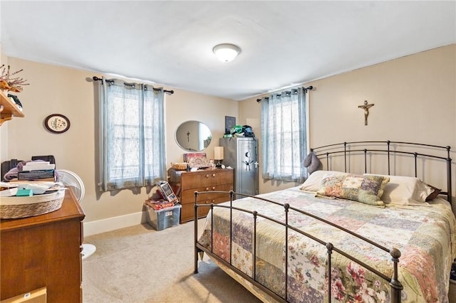 bedroom with baseboards and light colored carpet
