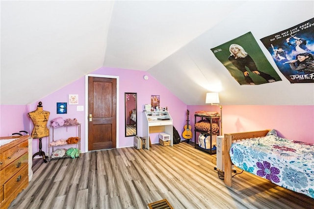 bedroom featuring lofted ceiling and wood finished floors