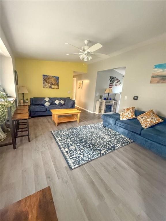 living room featuring a ceiling fan and wood finished floors