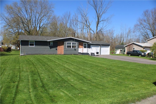 ranch-style home with a front lawn and aphalt driveway
