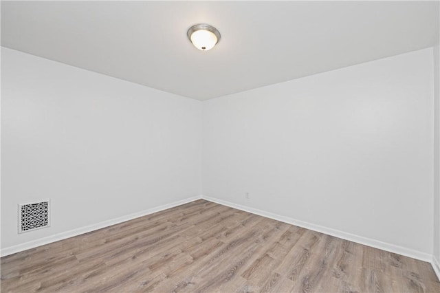 unfurnished room with baseboards, visible vents, and light wood-style floors