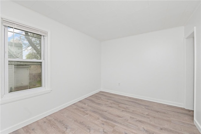 empty room featuring baseboards and light wood-type flooring