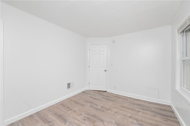 empty room with baseboards, wood finished floors, and visible vents