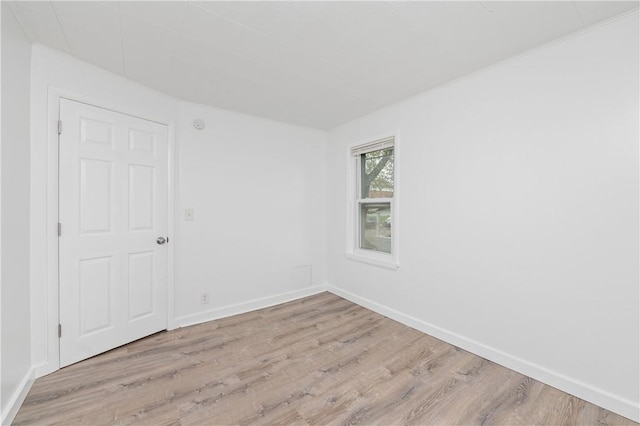 unfurnished room with baseboards and wood finished floors