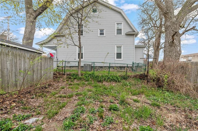 back of house with a fenced backyard and cooling unit