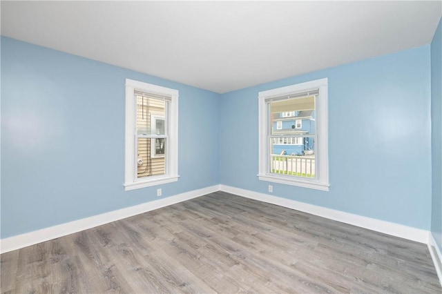 unfurnished room featuring baseboards and wood finished floors