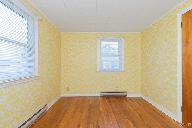 314 Westlind Rd, Geddes, NY 13219 - spare room featuring baseboard heating, baseboards, wood-type flooring, a baseboard heating unit, and ornamental molding