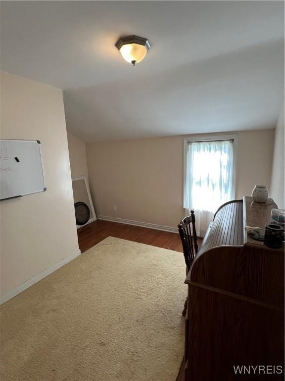 office featuring baseboards, vaulted ceiling, and wood finished floors