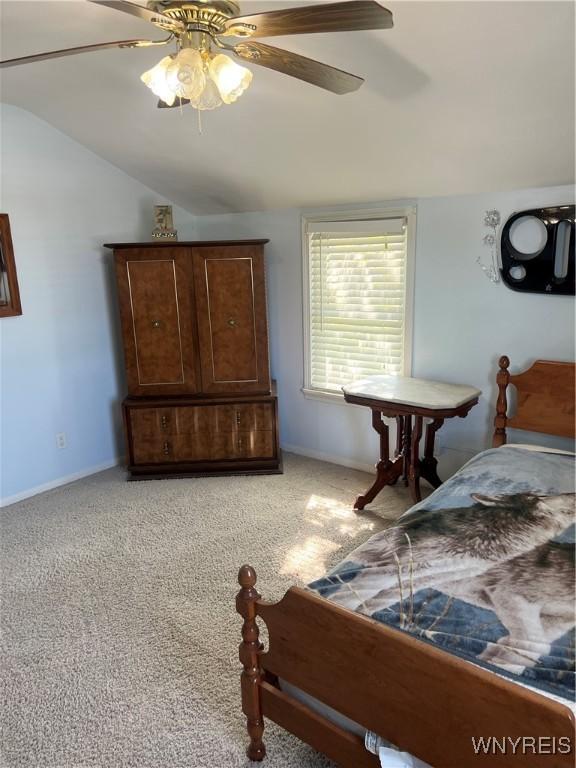 bedroom with a ceiling fan, baseboards, light carpet, and lofted ceiling