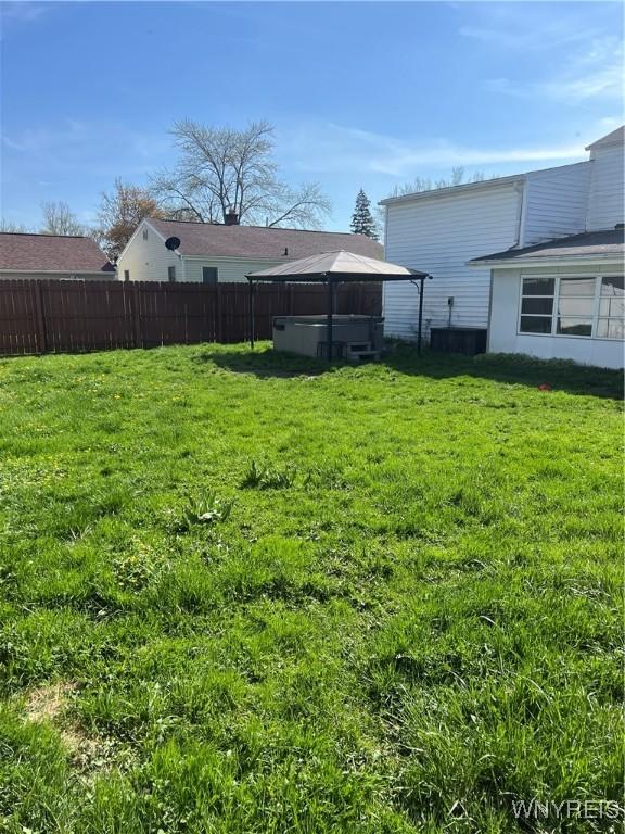 view of yard featuring a gazebo, a jacuzzi, and fence