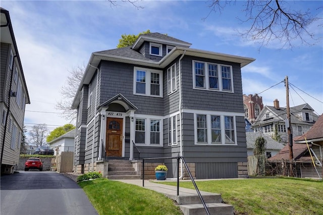 american foursquare style home featuring a front yard