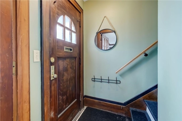 foyer with baseboards and stairway