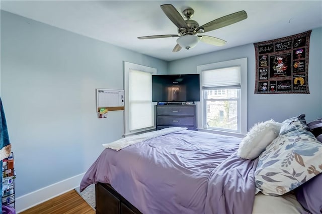 bedroom with baseboards, a ceiling fan, and wood finished floors
