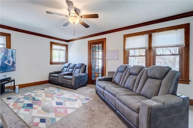 living room featuring a ceiling fan, baseboards, light carpet, and ornamental molding