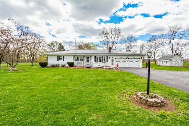 single story home featuring a porch, driveway, a chimney, a front yard, and an attached garage