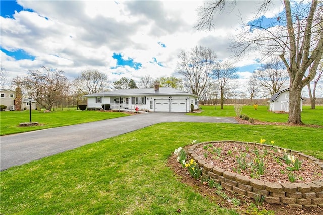 ranch-style home with an attached garage, a front lawn, driveway, and a chimney
