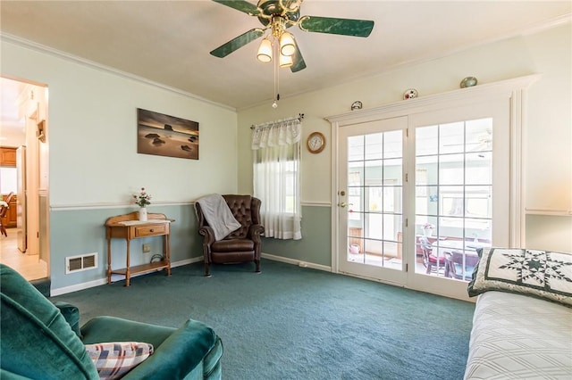 sitting room featuring ceiling fan, carpet, ornamental molding, and visible vents