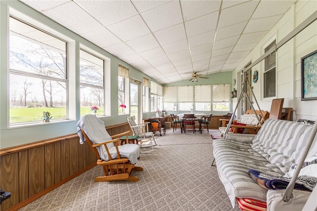 sunroom with carpet flooring, wainscoting, wood walls, and plenty of natural light