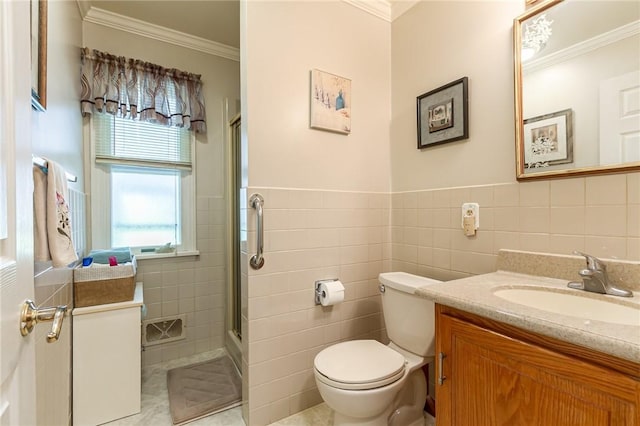 bathroom with vanity, crown molding, toilet, tile walls, and a shower with shower door