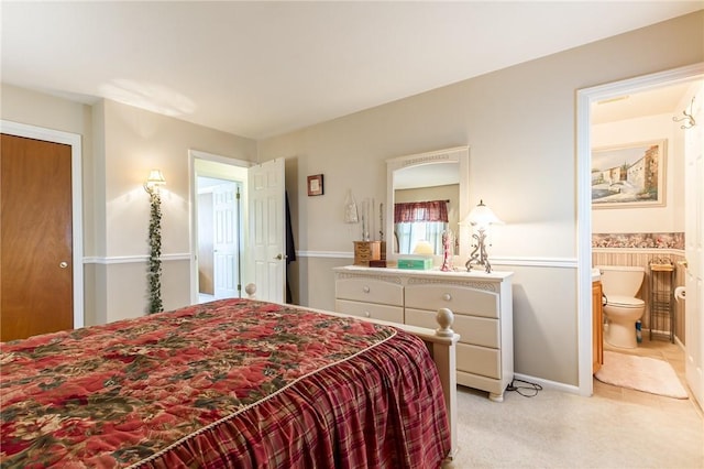 bedroom with light colored carpet and connected bathroom