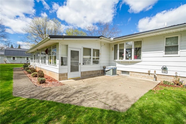 back of property with a lawn and a patio area