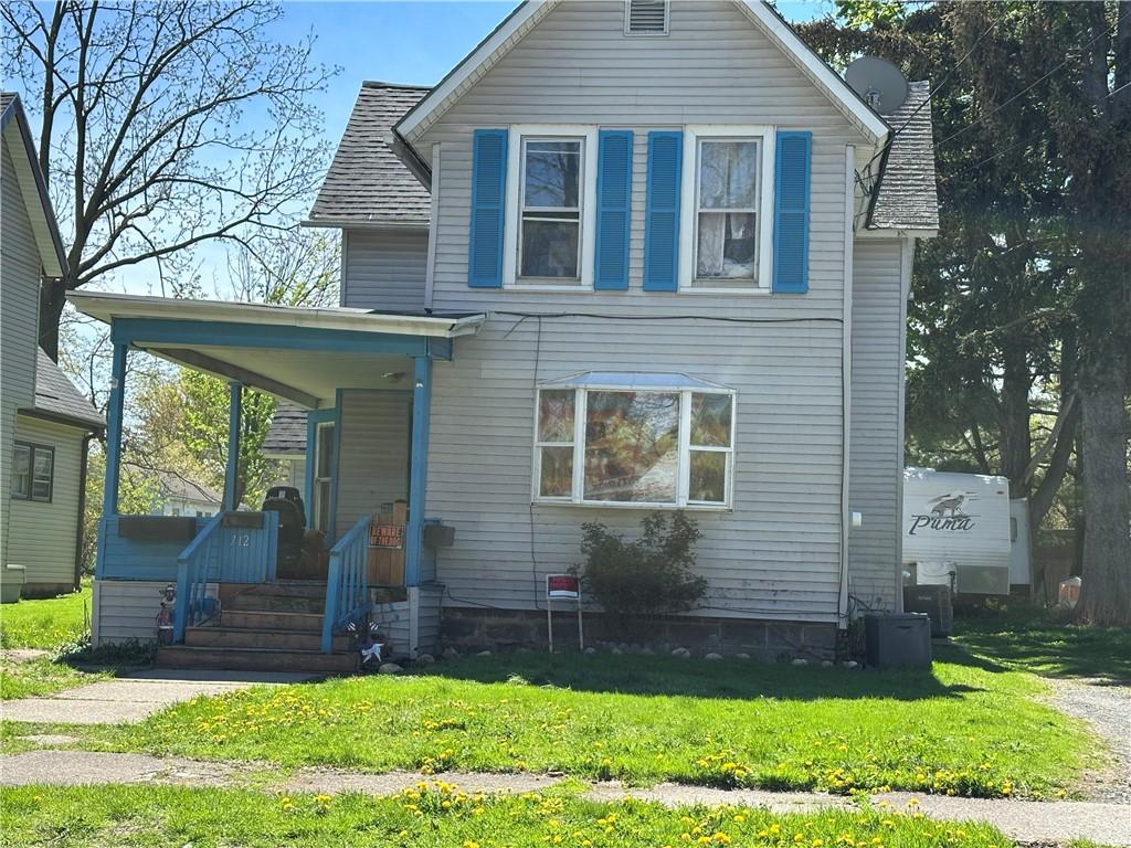 view of front of house featuring covered porch and a front yard