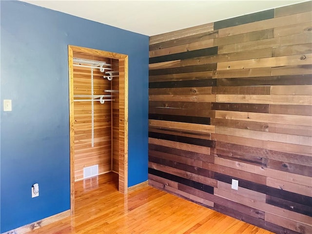 5291 Starr Rd, Thurston, NY 14821 - unfurnished bedroom with wooden walls, baseboards, wood finished floors, and visible vents