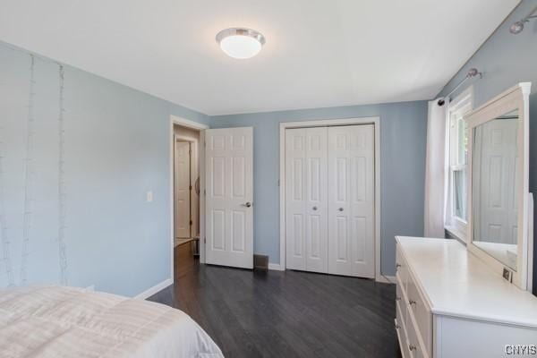 bedroom featuring a closet, dark wood-style flooring, and baseboards