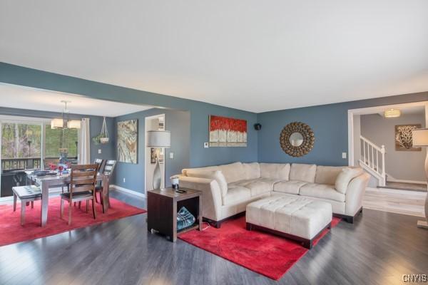 living area with stairway, baseboards, and wood finished floors