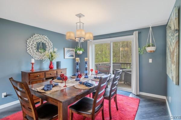 dining room featuring baseboards, wood finished floors, and a chandelier
