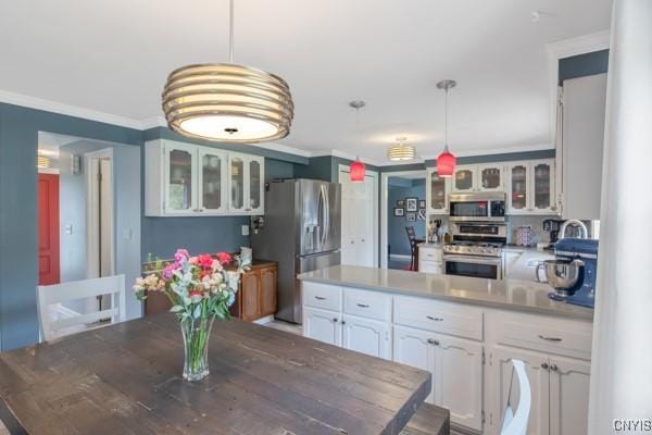 kitchen with ornamental molding, a peninsula, glass insert cabinets, white cabinets, and appliances with stainless steel finishes