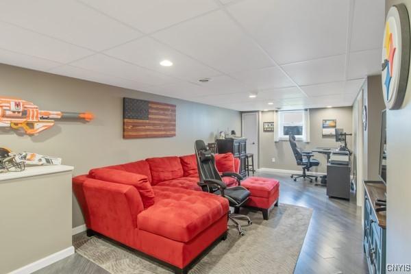 living area featuring recessed lighting, baseboards, a drop ceiling, and wood finished floors