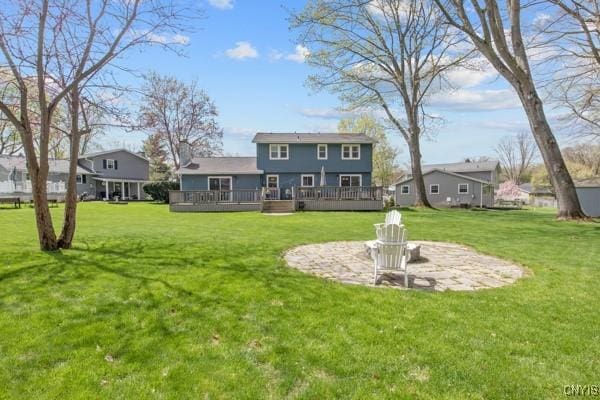 back of property featuring a lawn and a wooden deck