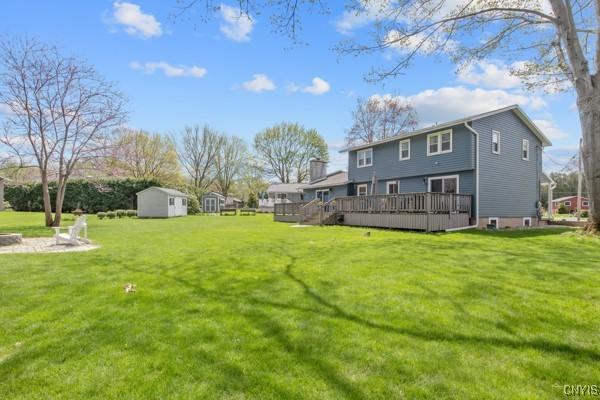 view of yard with an outdoor structure, a storage shed, and a deck