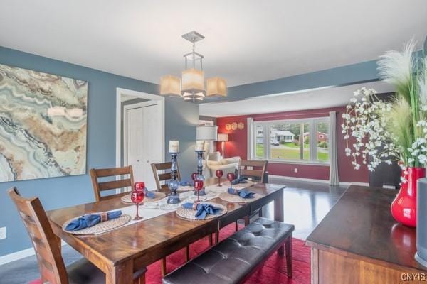 dining room featuring baseboards and a chandelier