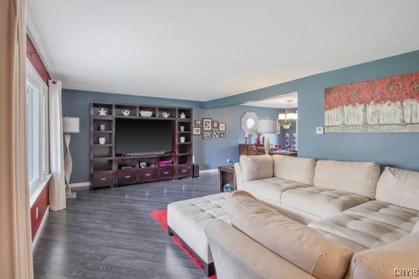living area with baseboards, dark wood-style flooring, and a notable chandelier