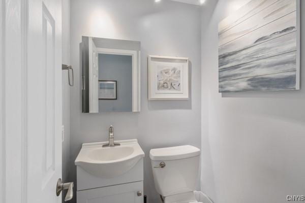 half bathroom featuring vanity and toilet