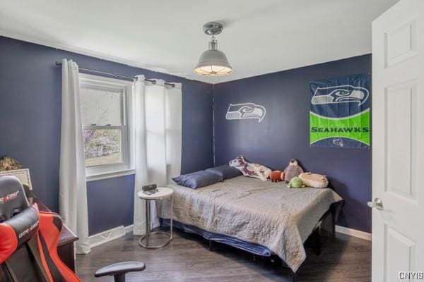 bedroom featuring baseboards and wood finished floors