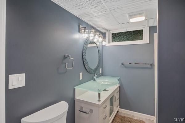 bathroom featuring vanity, baseboards, and toilet
