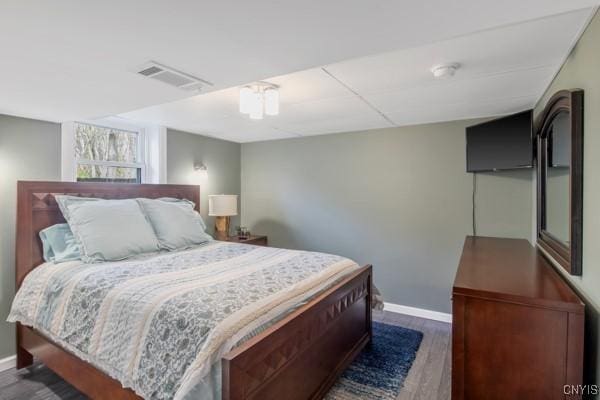 bedroom featuring baseboards, visible vents, and wood finished floors