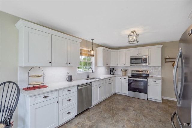 kitchen with a sink, appliances with stainless steel finishes, white cabinets, and backsplash