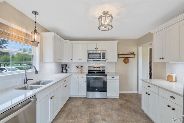 kitchen featuring light countertops, white cabinetry, tasteful backsplash, a sink, and stainless steel appliances