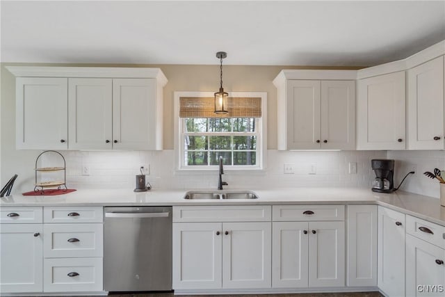 kitchen featuring stainless steel dishwasher, white cabinets, decorative backsplash, and a sink