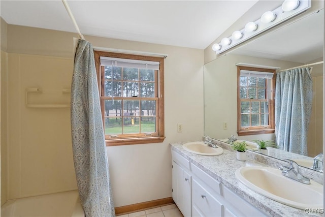 full bathroom with double vanity, tile patterned floors, curtained shower, and a sink